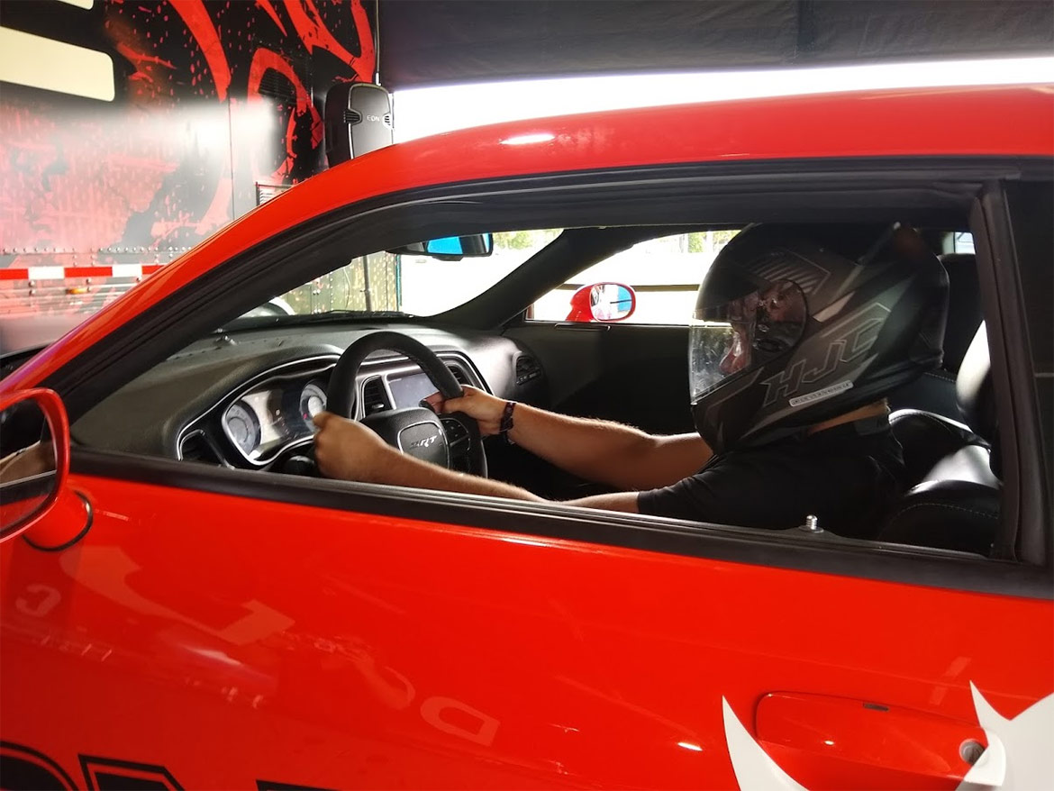 Enthusiast wearing a helmet driving a dodge vehicle simulator