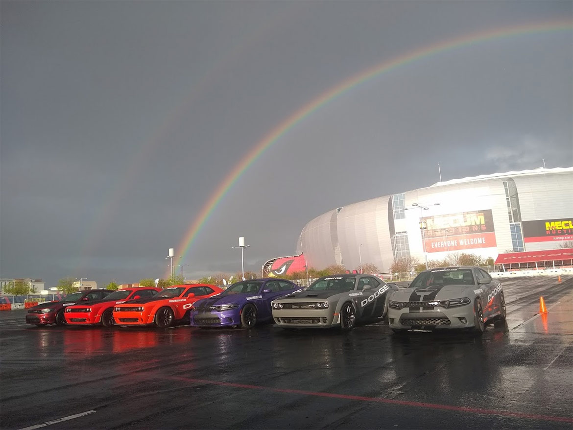 Dodge vehicles lined up under a rainbow