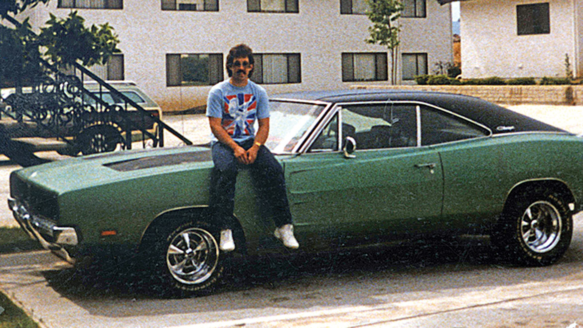 lee storz sitting on the hood of his dodge charger