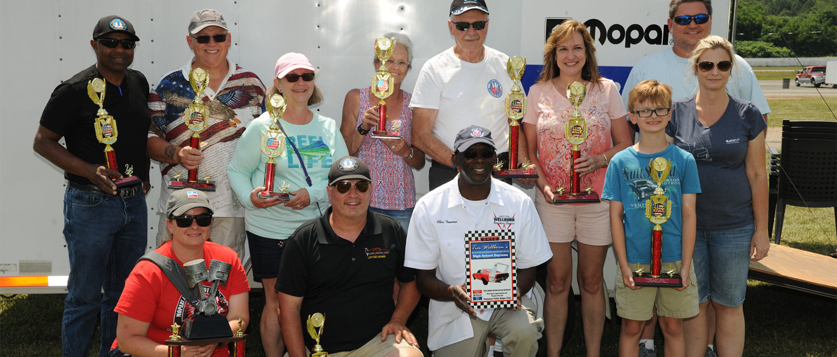 group of people holding trophies