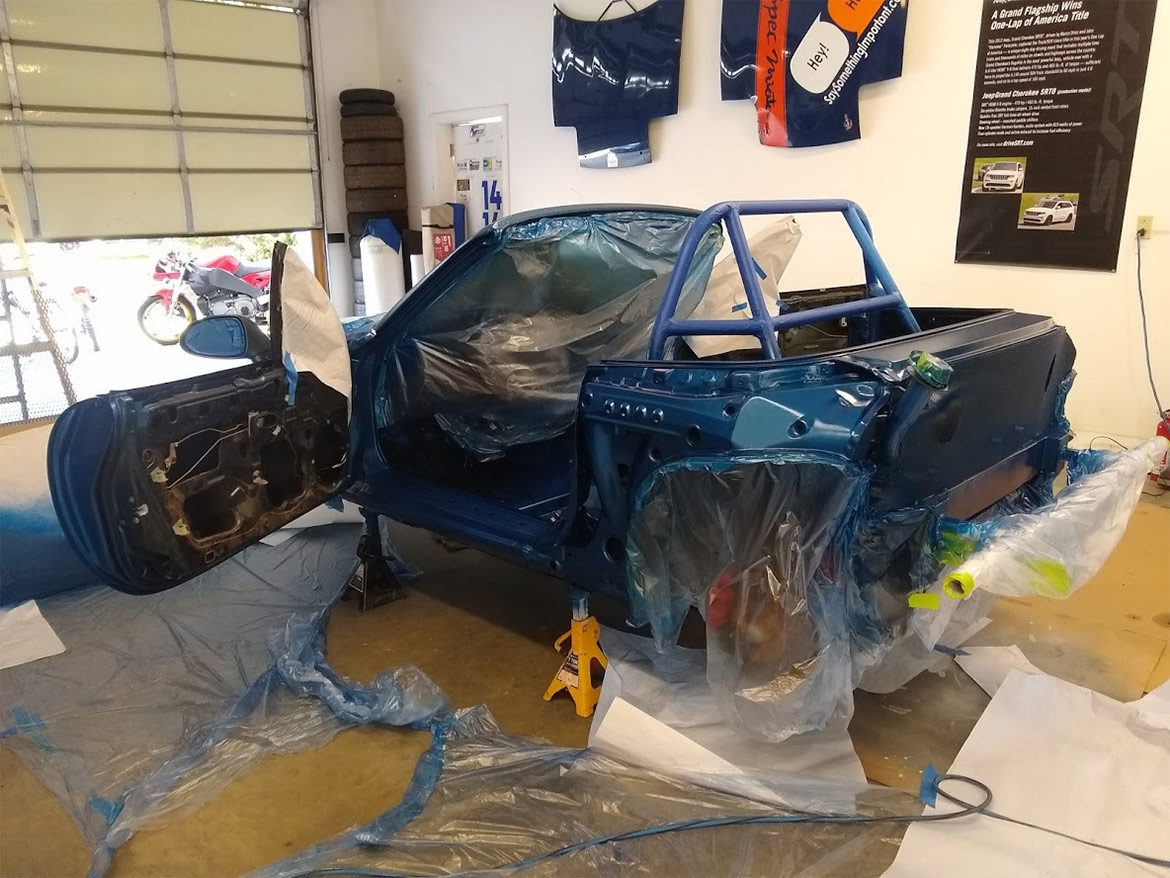 exo car being painted in a garage