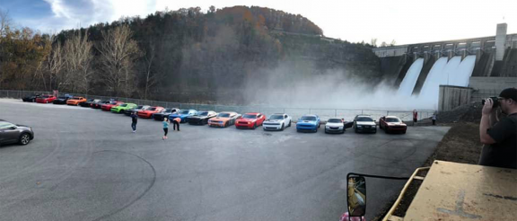 vehicles lined up next to waterfalls