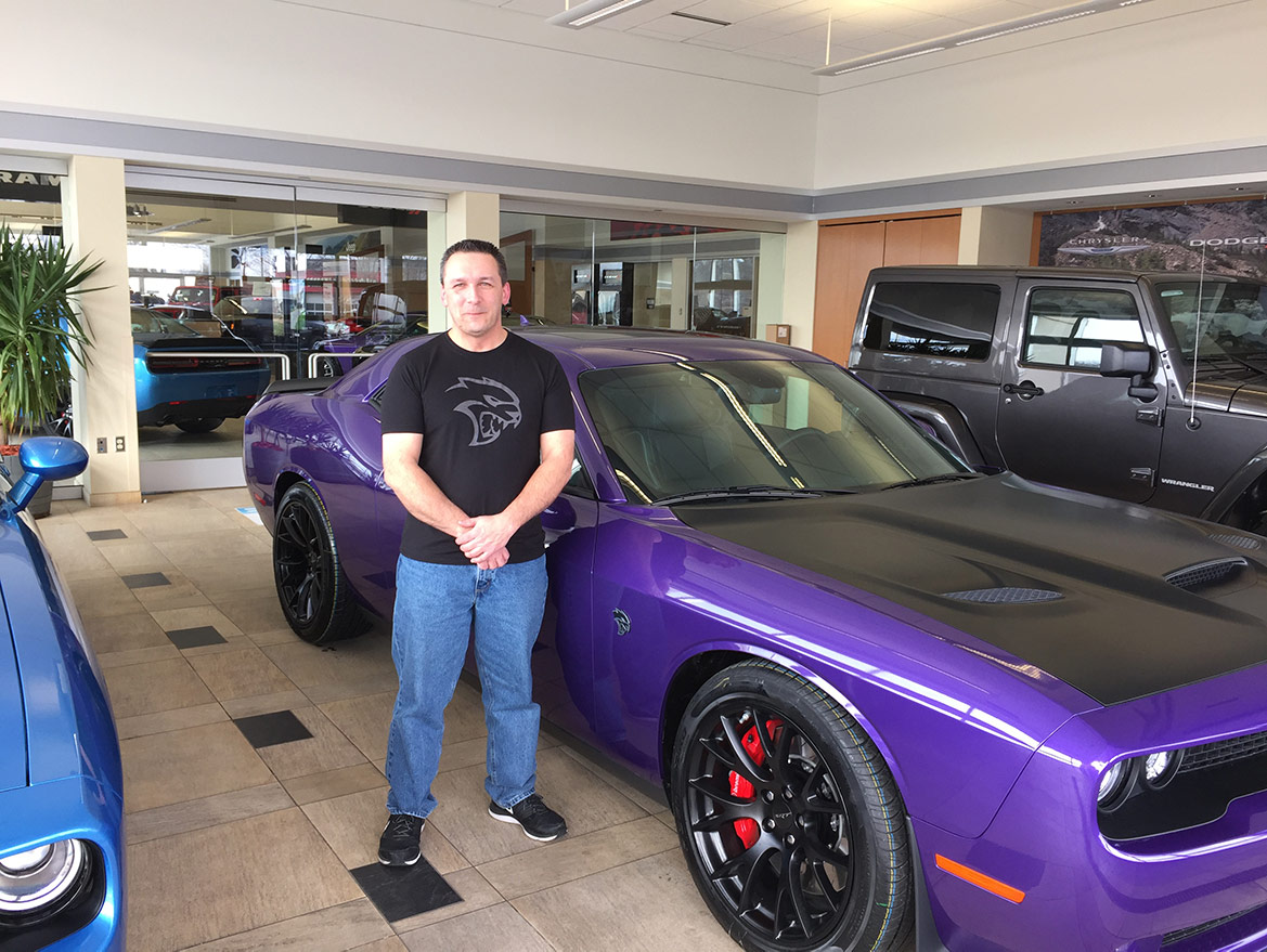 man standing with a dodge vehicle