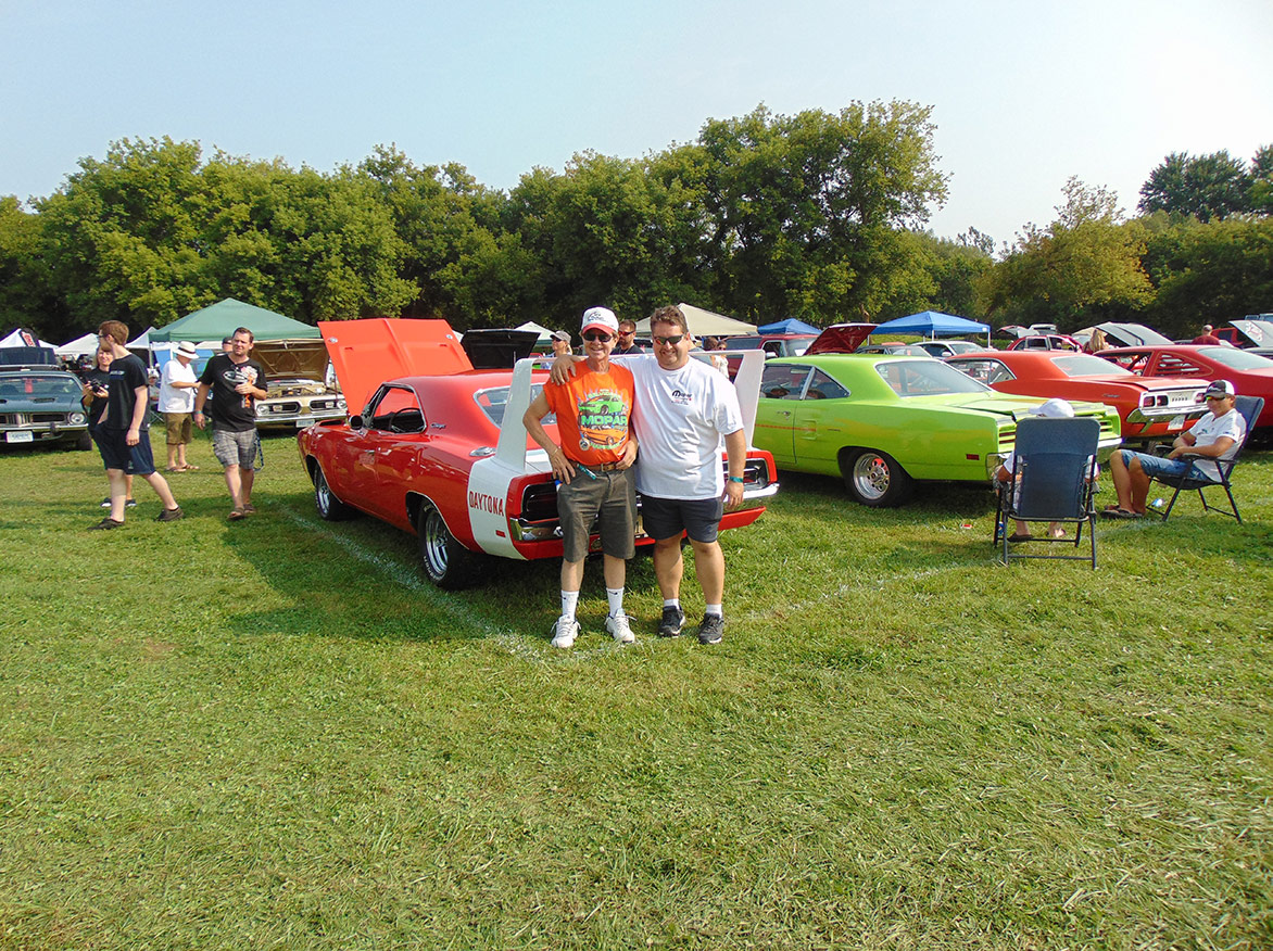 two men standing with a vehicle