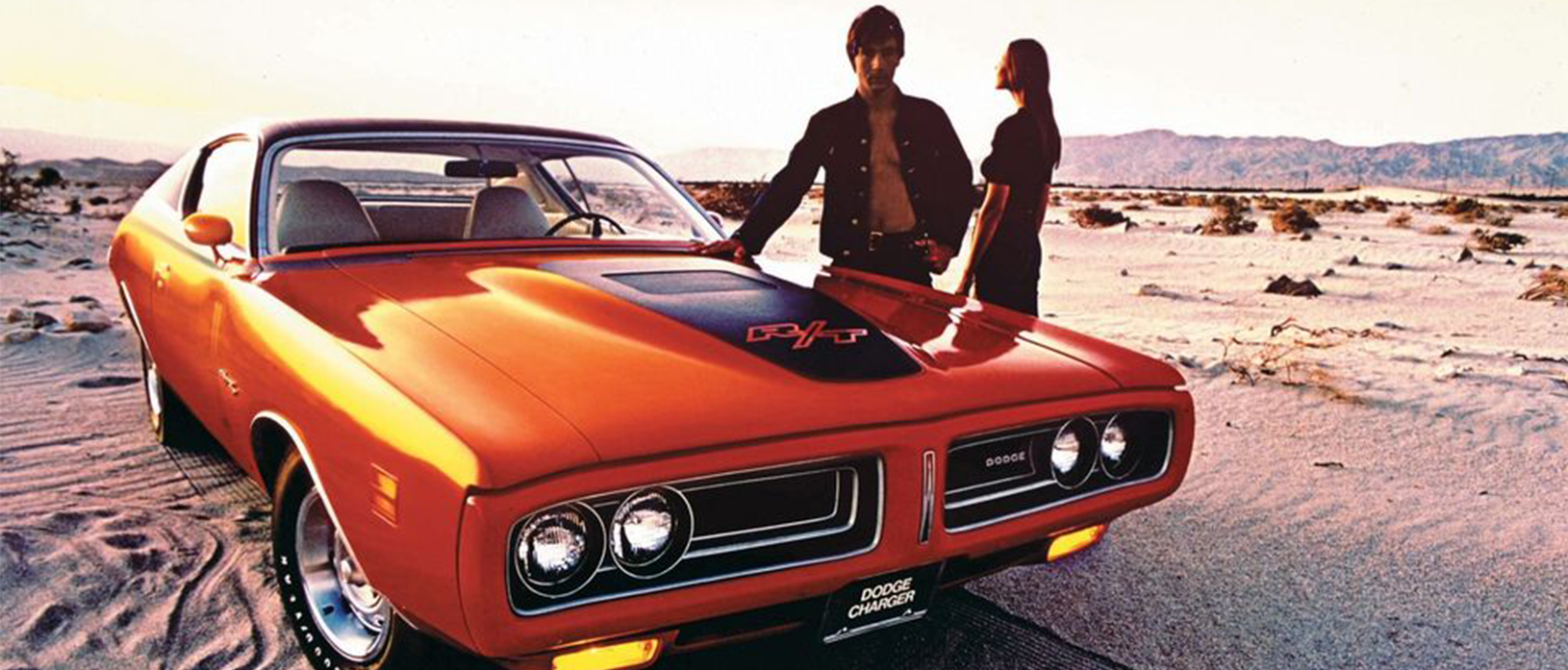 two people standing with a dodge vehicle