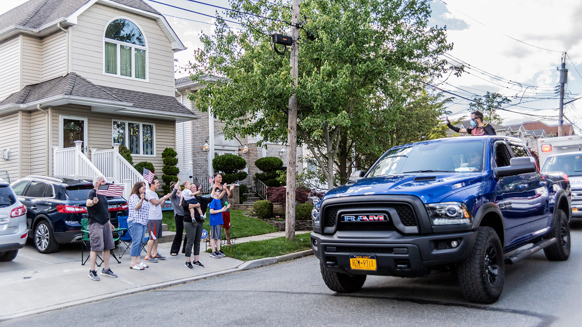 spectators waving at parade vehicles