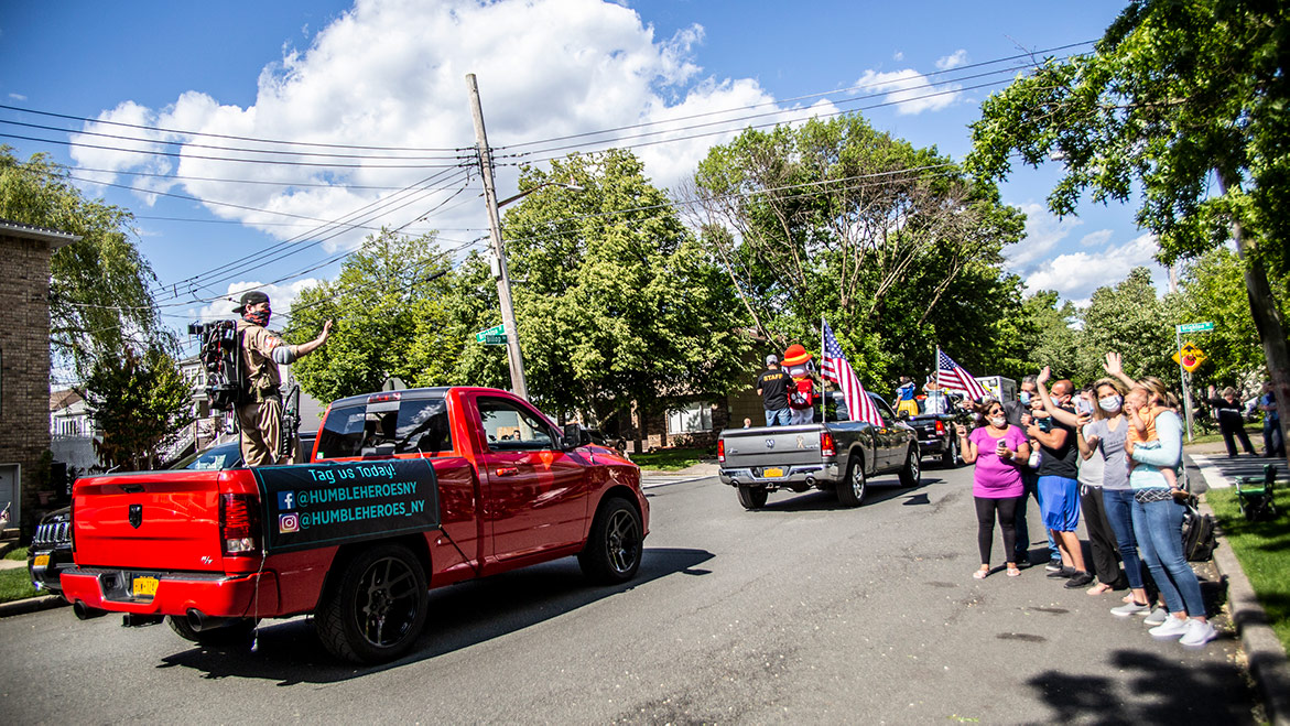 spectators waving at parade vehicles