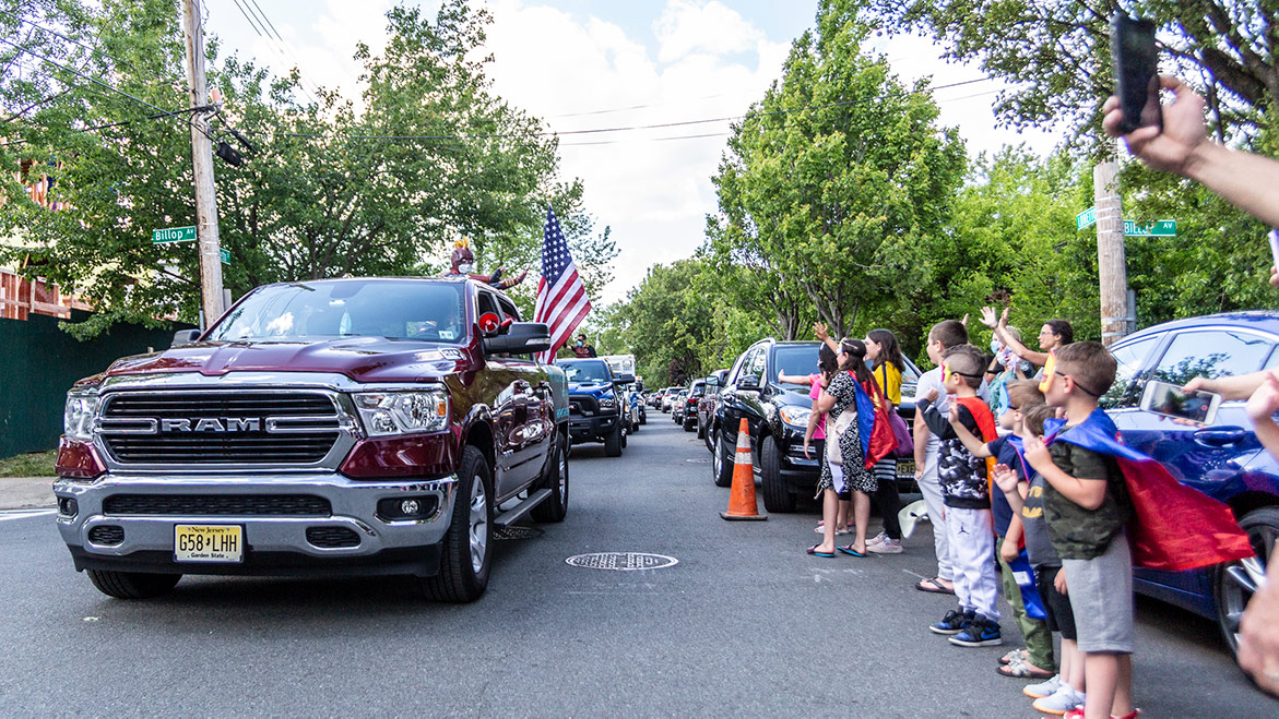 spectators waving at parade vehicles