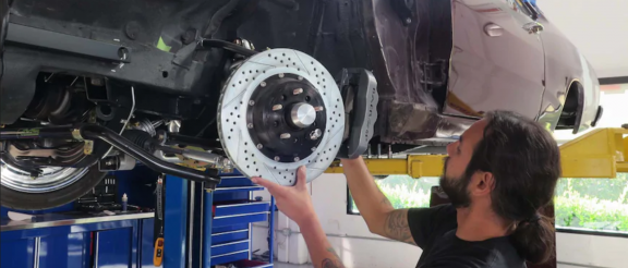 man installing brakes on a vehicle