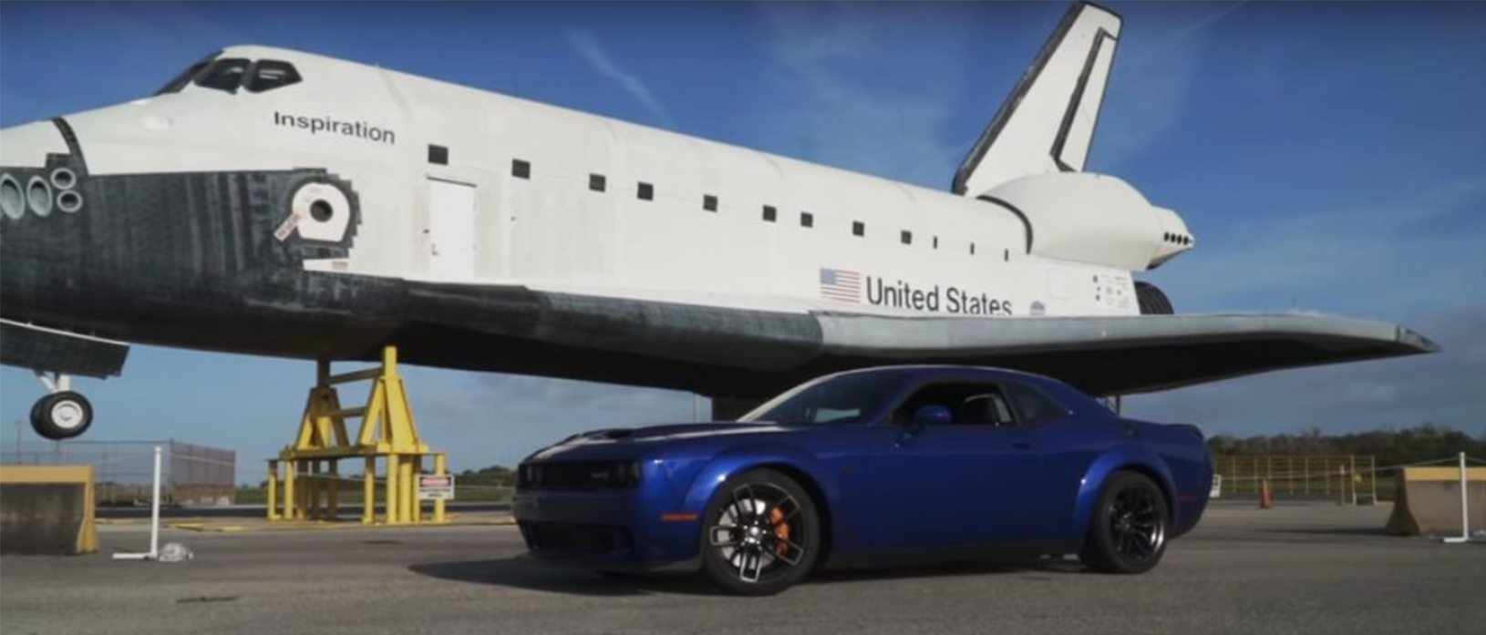Dodge vehicle parked next to an airplane