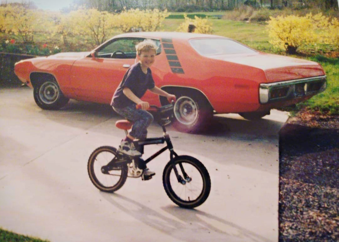 child riding a bike near a vehicle