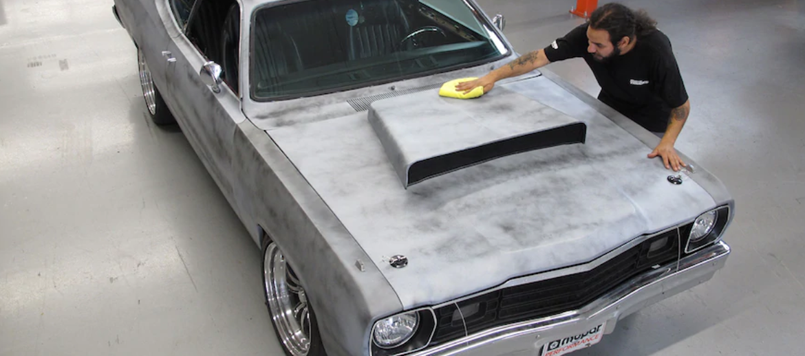 Man working on the hood of a vehicle