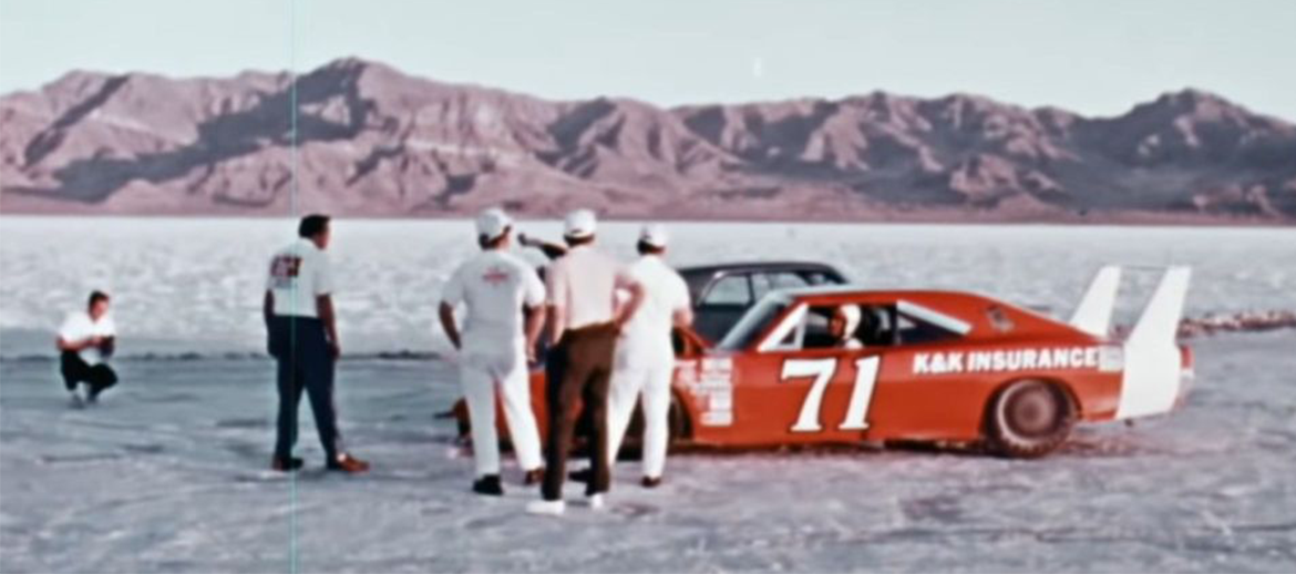 drivers standing around a vehicle