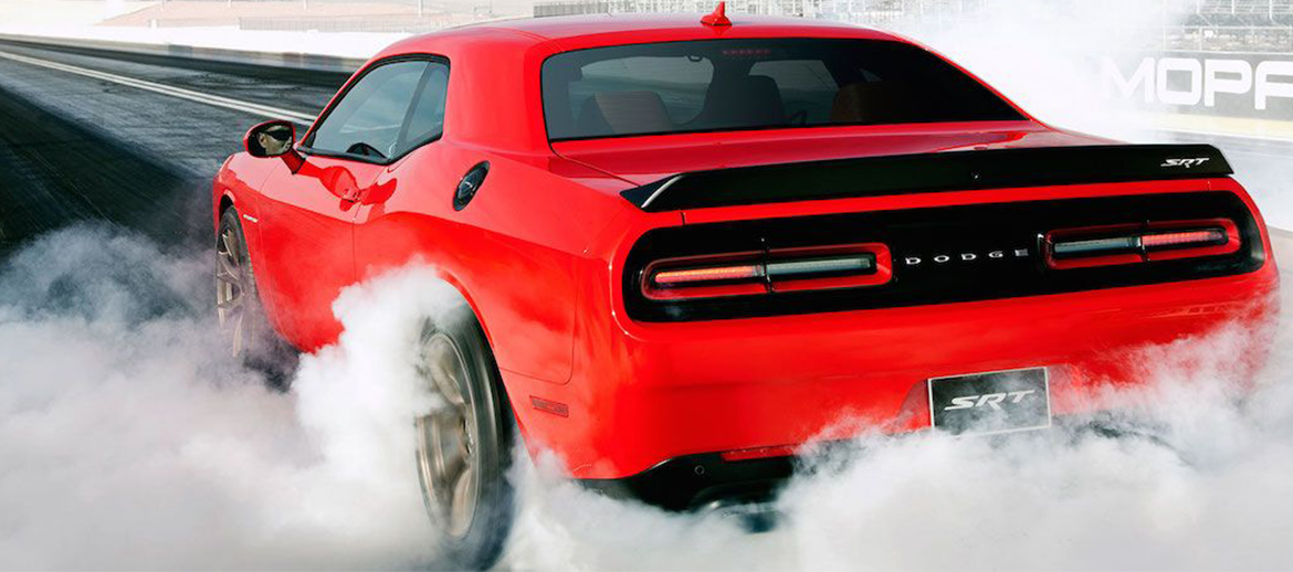 challenger doing a burnout on a drag strip