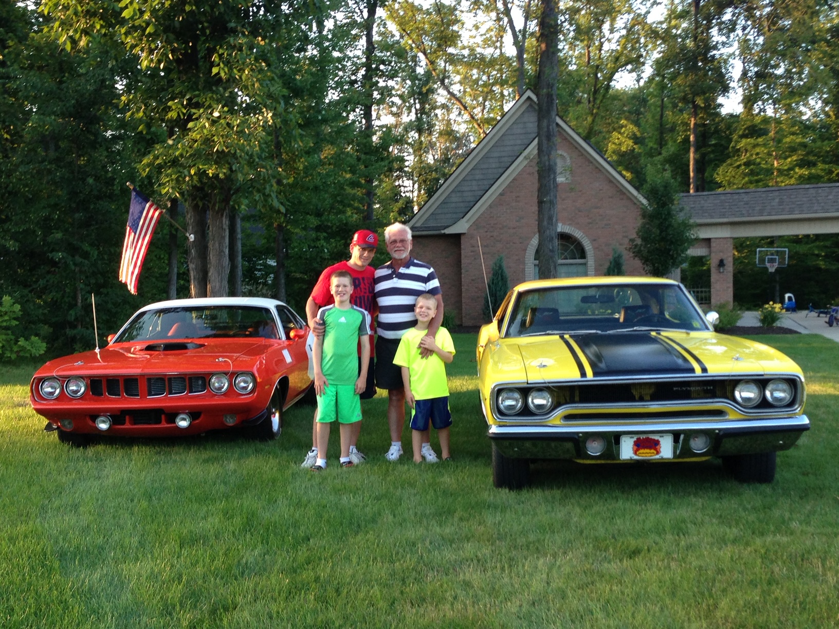 Raymond, Brian, Zachary, Dominic, orange 1971 Plymouth Cuda and   yellow 1970 Plymouth Road Runner with black hood stripes