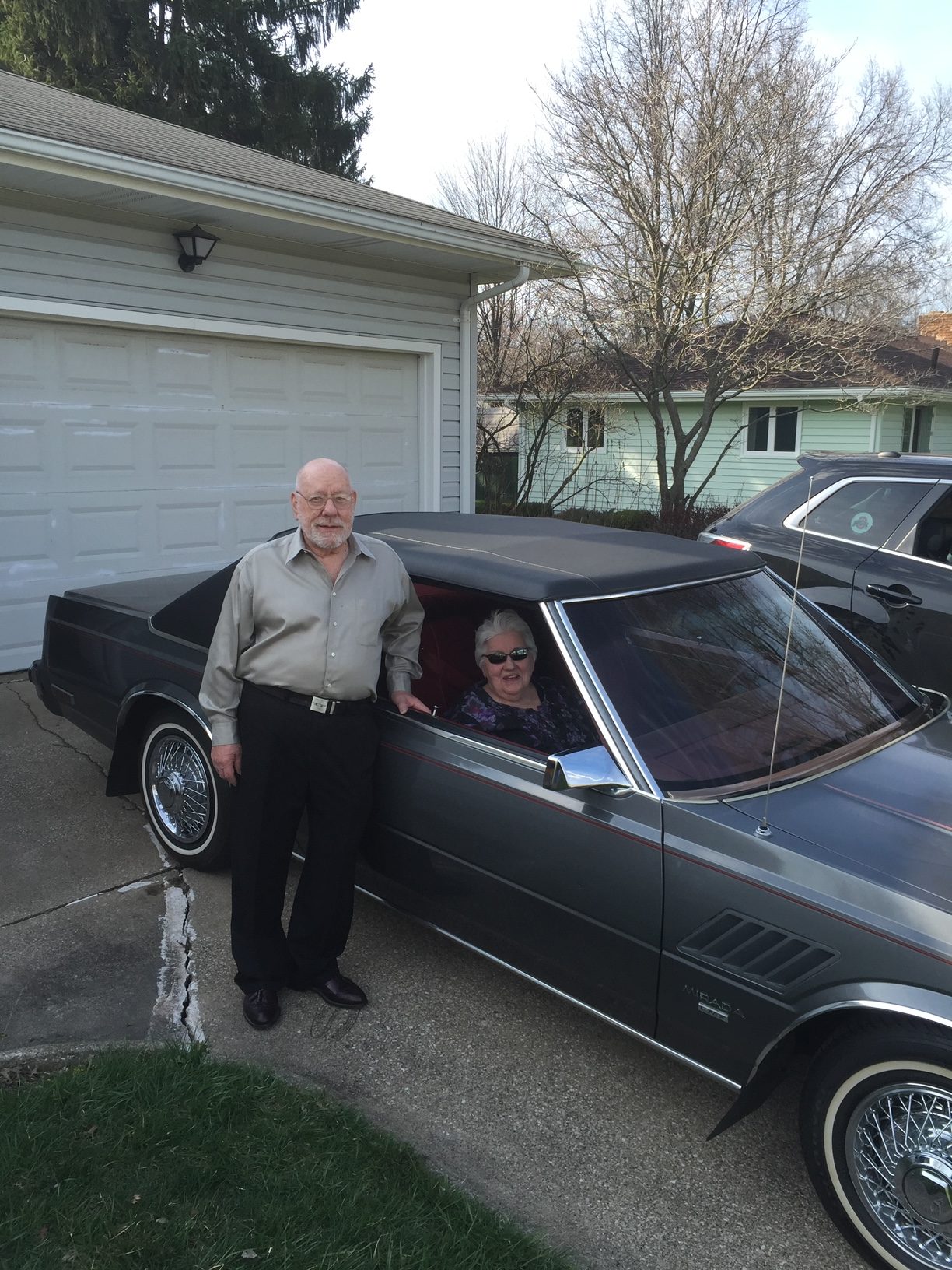 Christina’s grandparents posing with by the gray 1982 Dodge Mirada CMX