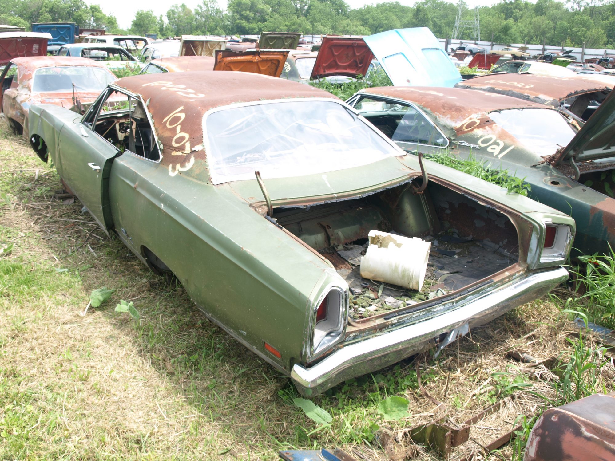 Classic Mopar vehicles sitting in a field at Mopar City