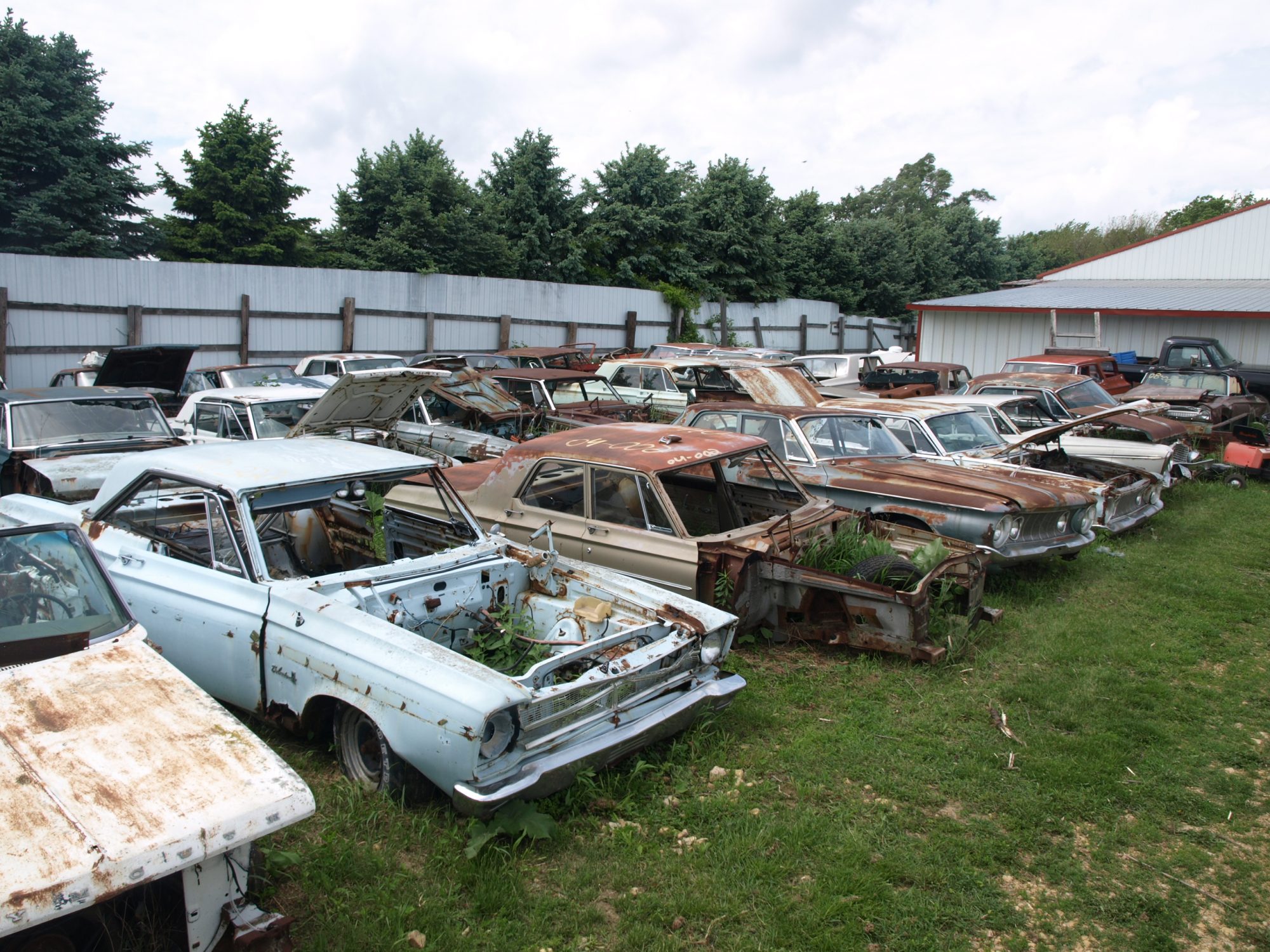 Classic Mopar vehicles sitting in a field at Mopar City