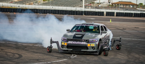 Dodge vehicle with training wheels doing a burnout