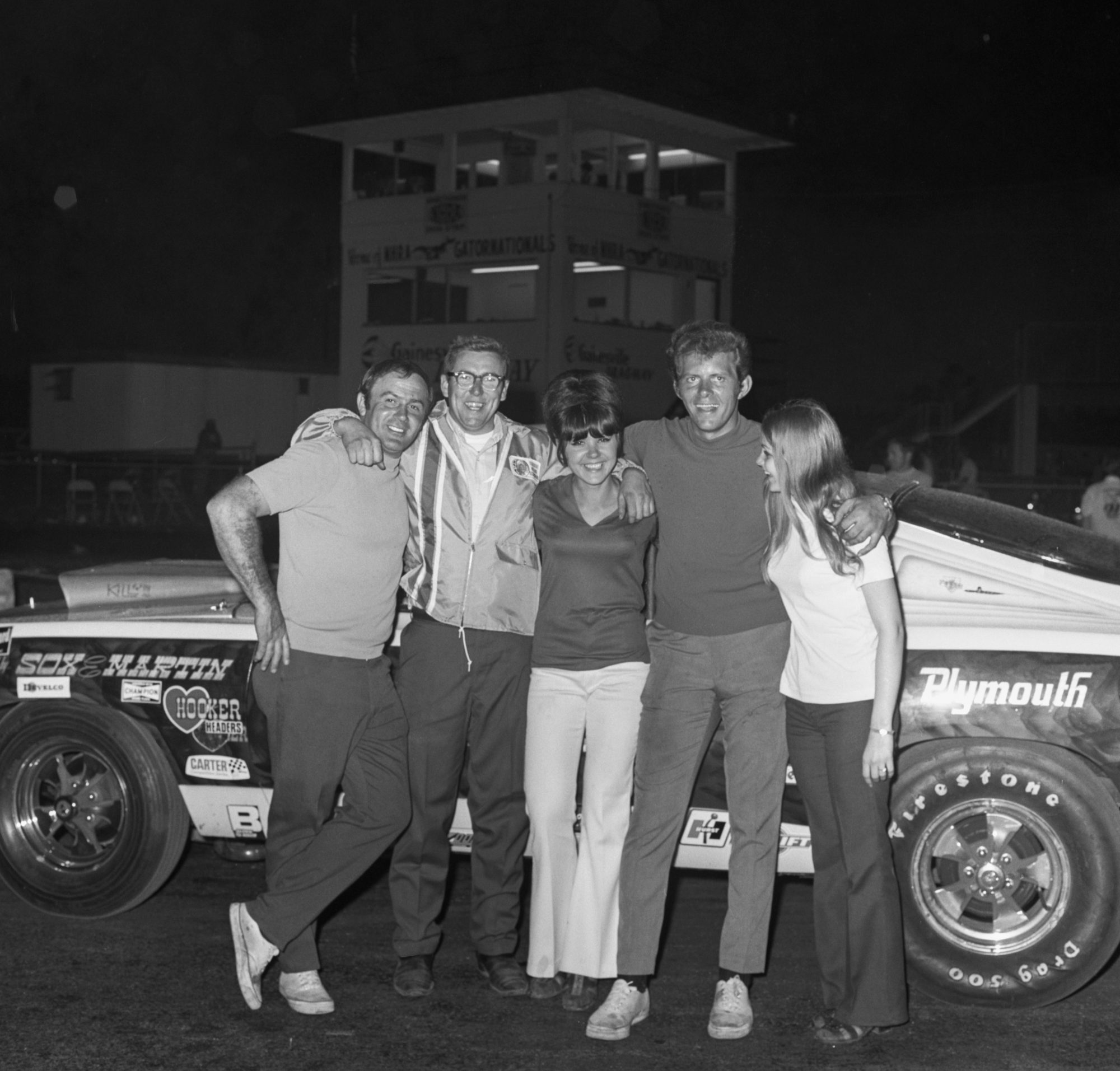 Herb McCandless posing with friends in front of his race car