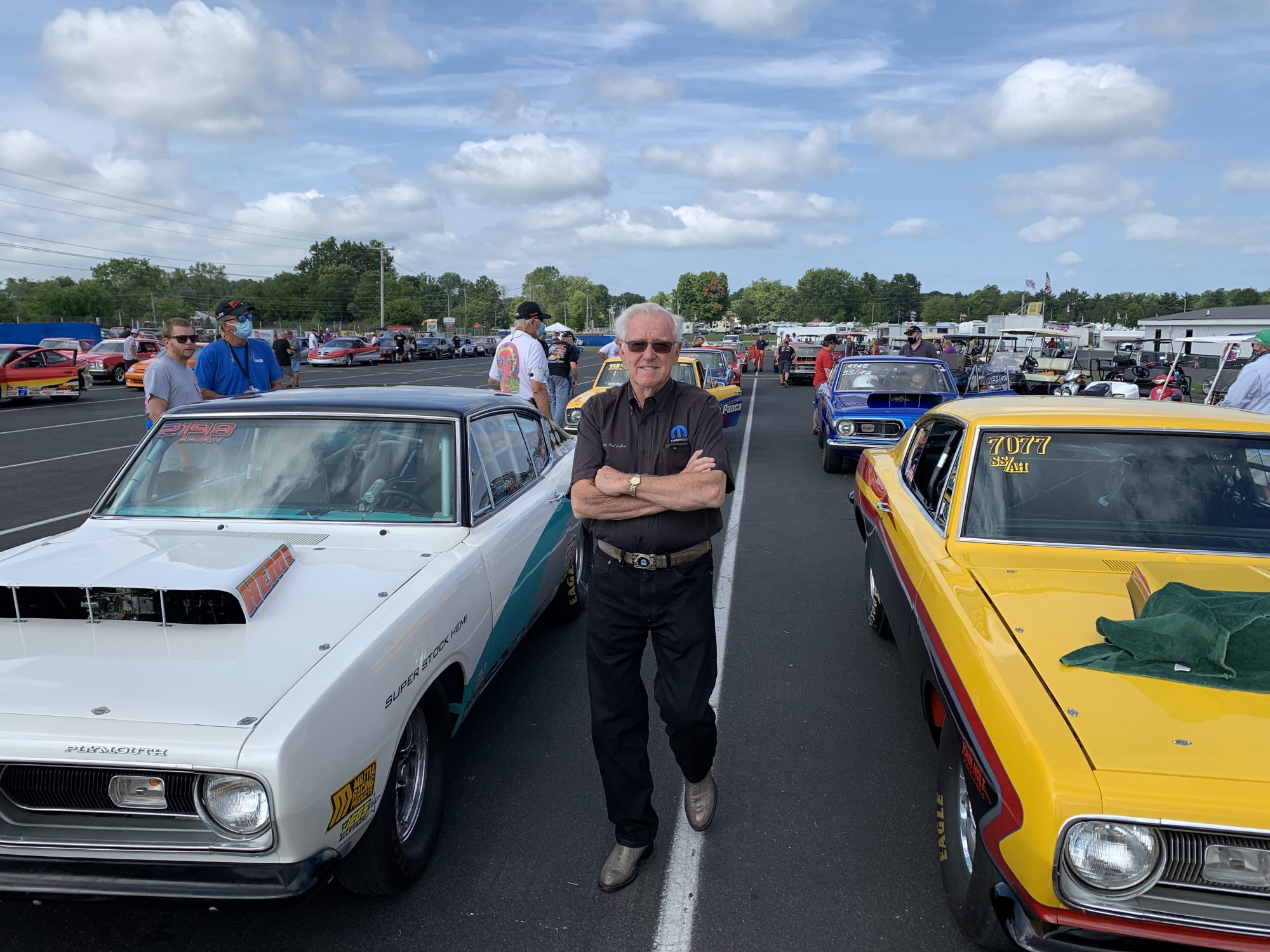 Herb McCandless posing next to race cars