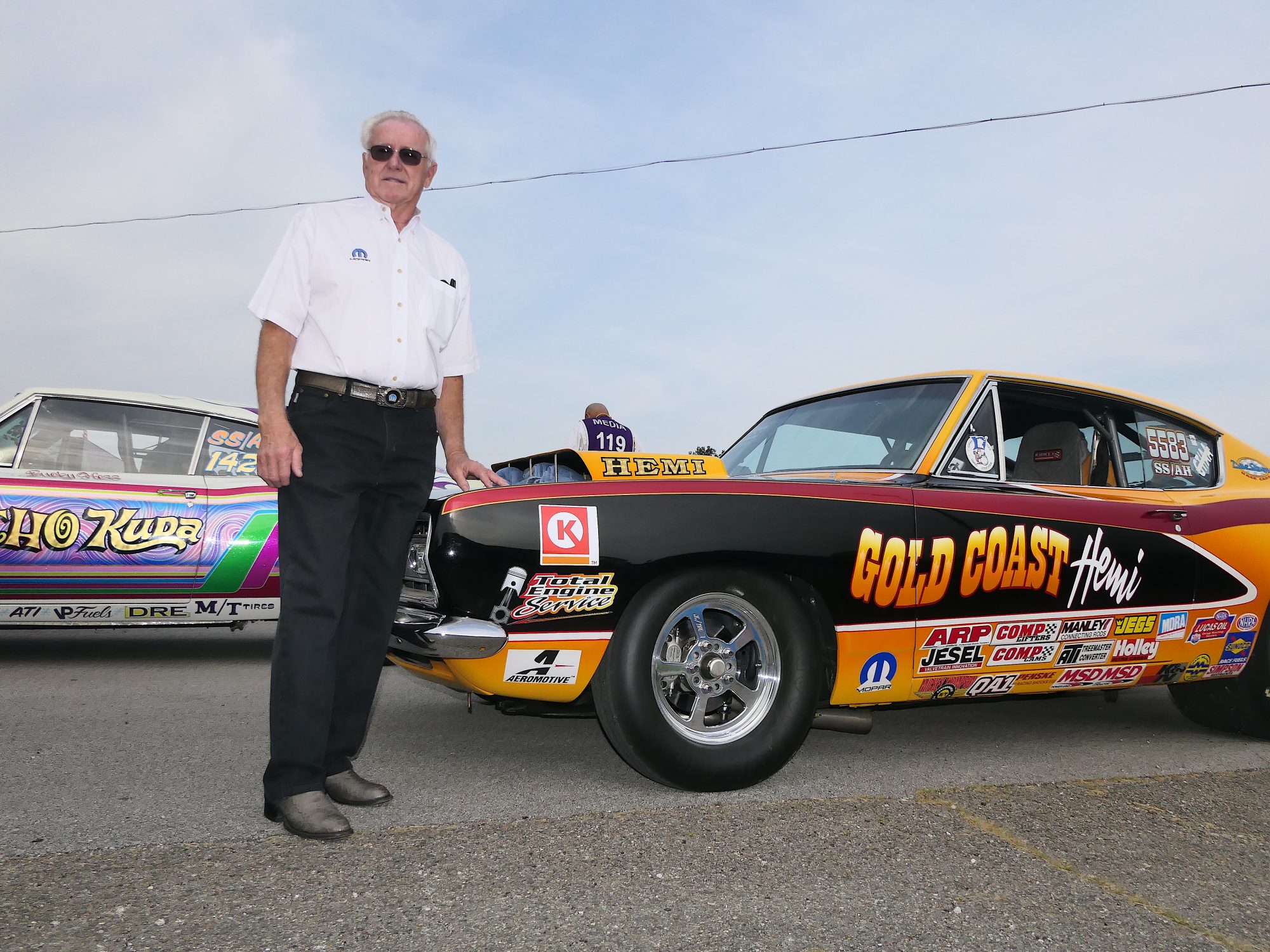 Herb McCandless posing next to his race car