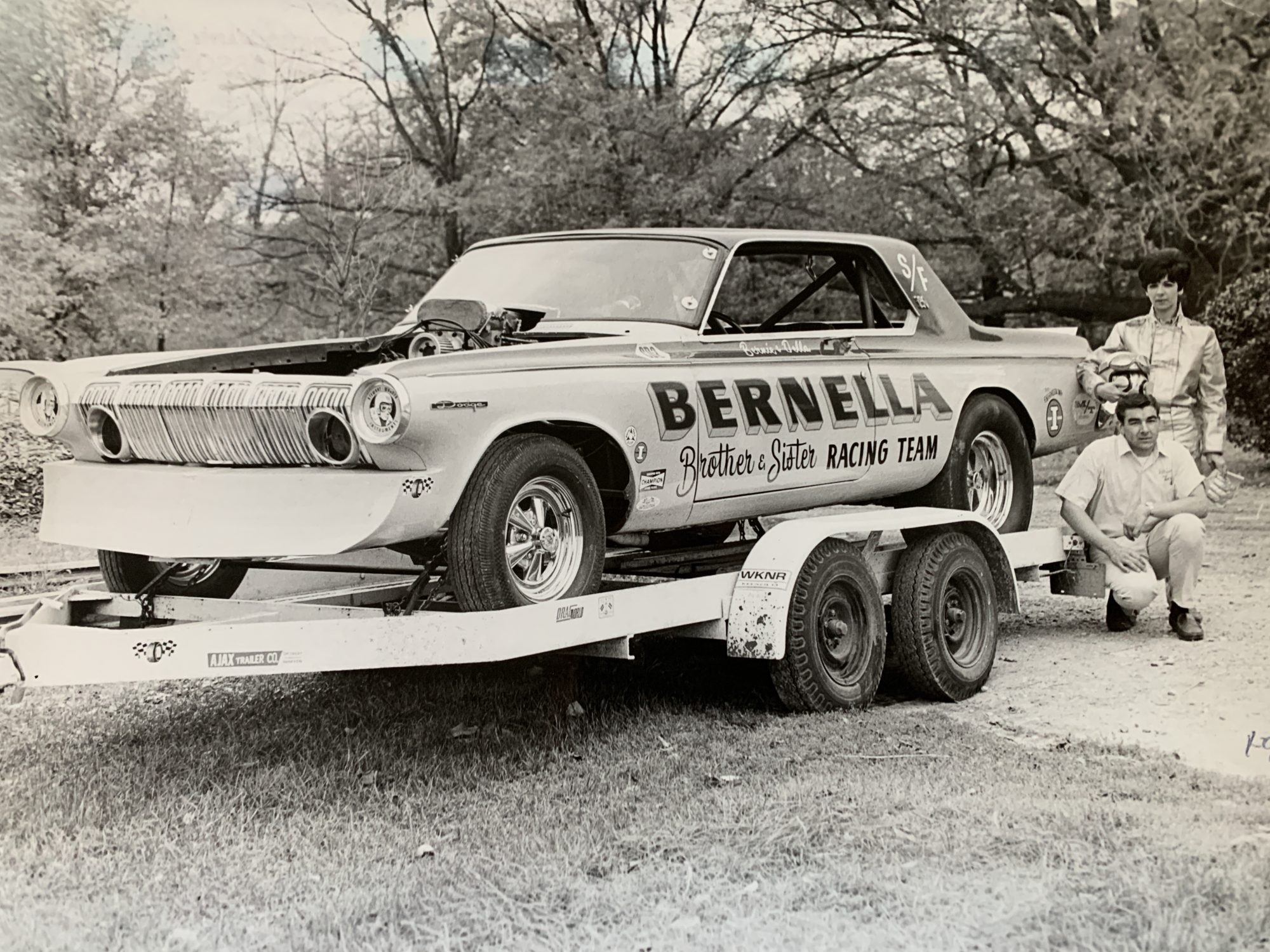 Della nd her brother posing next to their race car