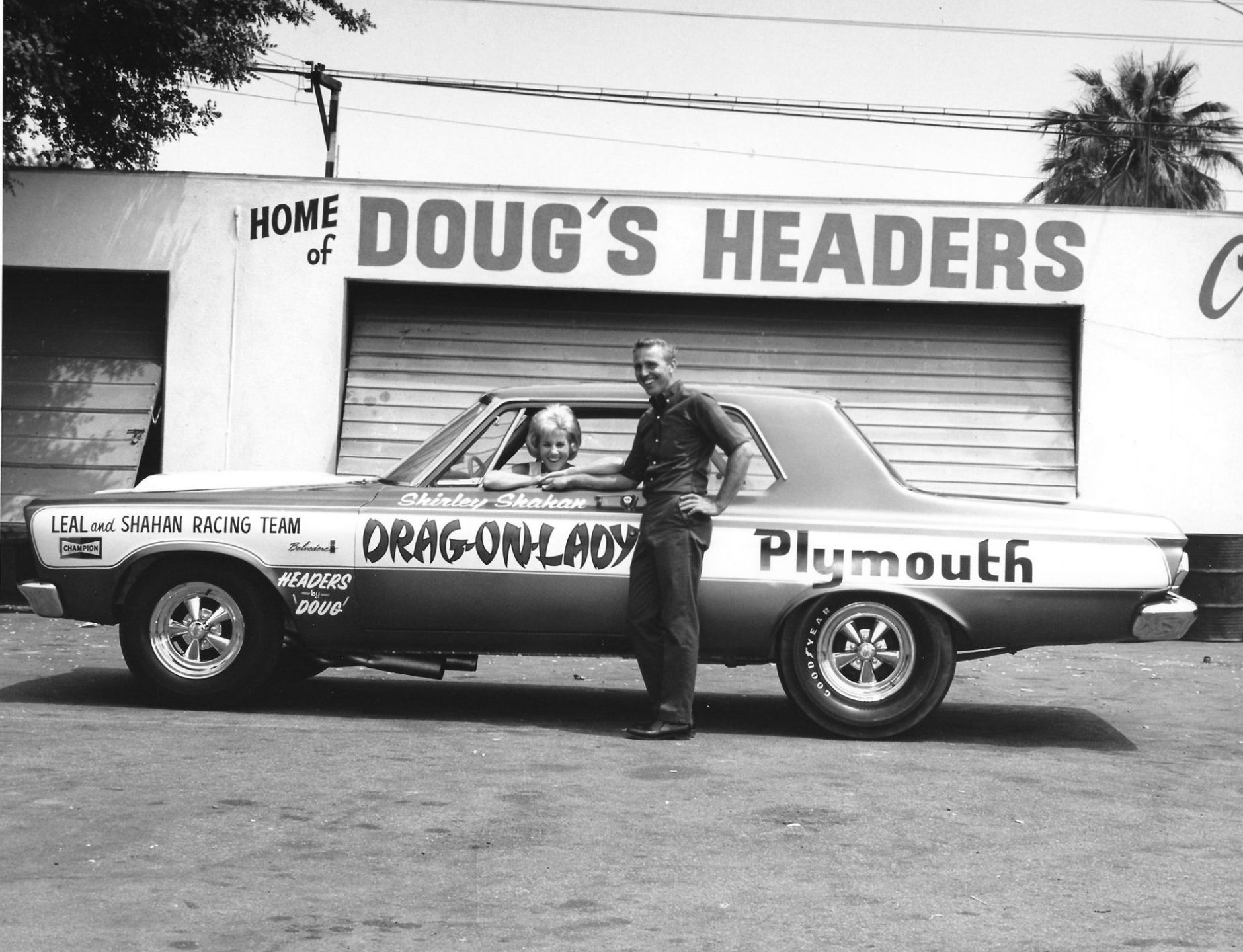 Shirley and H.L. posing with their drag car