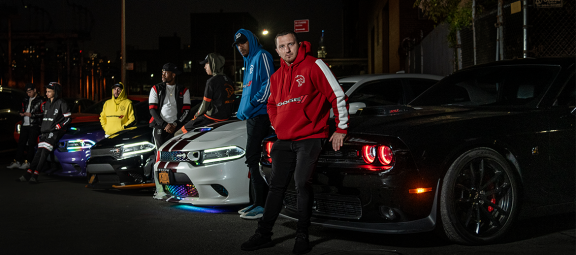 men standing next to Dodge cars wearing Dodge merchandise