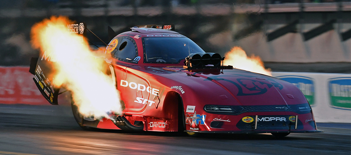 Funny Car with flames coming off it on a drag strip