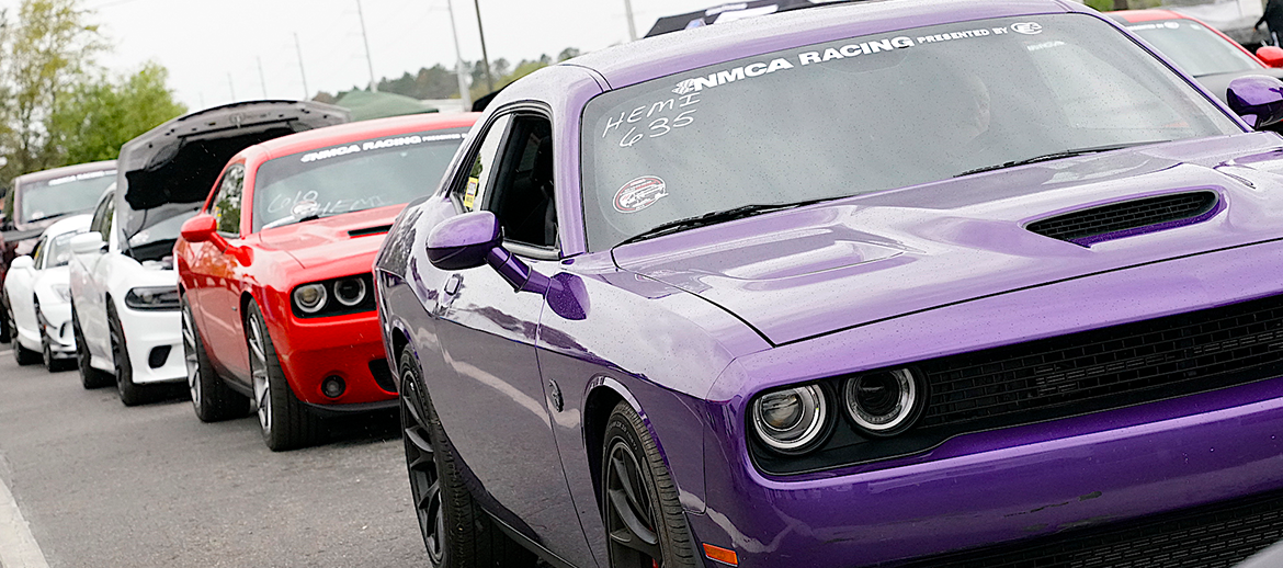 Line of Dodge Chargers and Challengers in the staging lanes at an NMCA race event