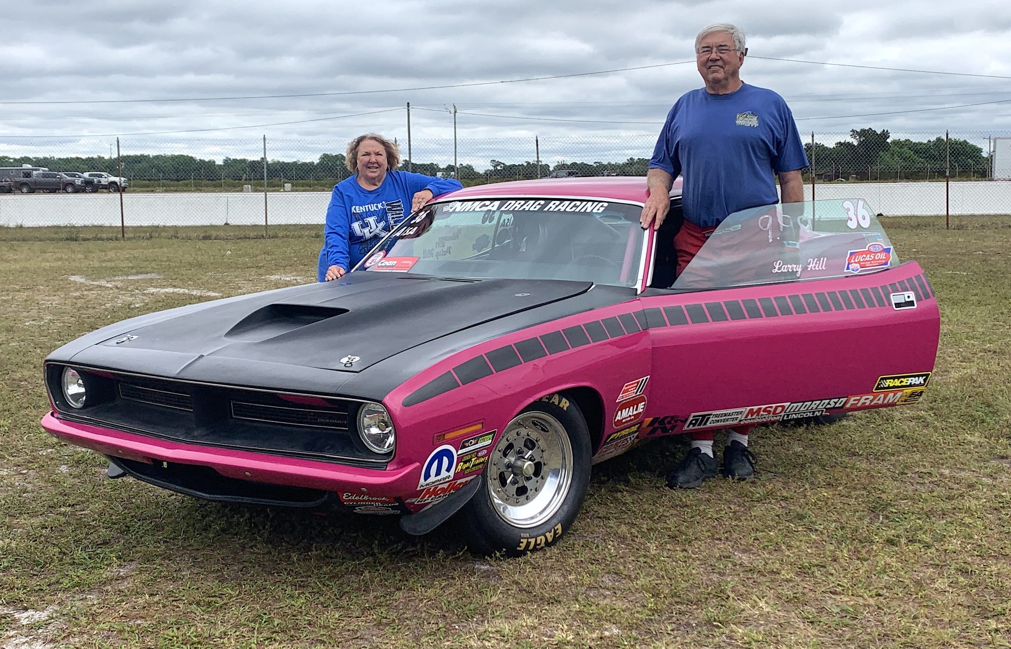 Larry Hill and his wife standing next to their car