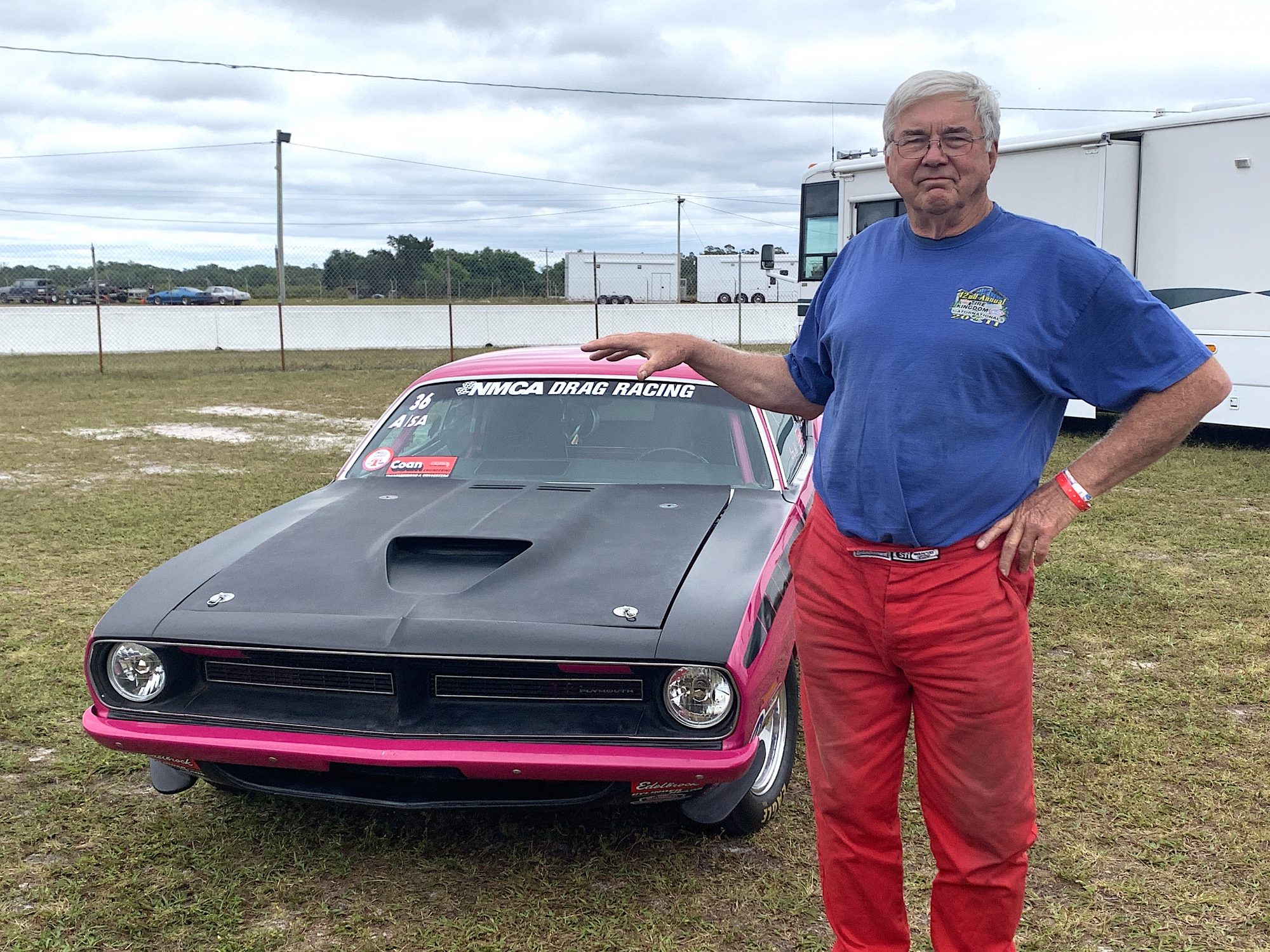 Larry Hill posing with his drag car