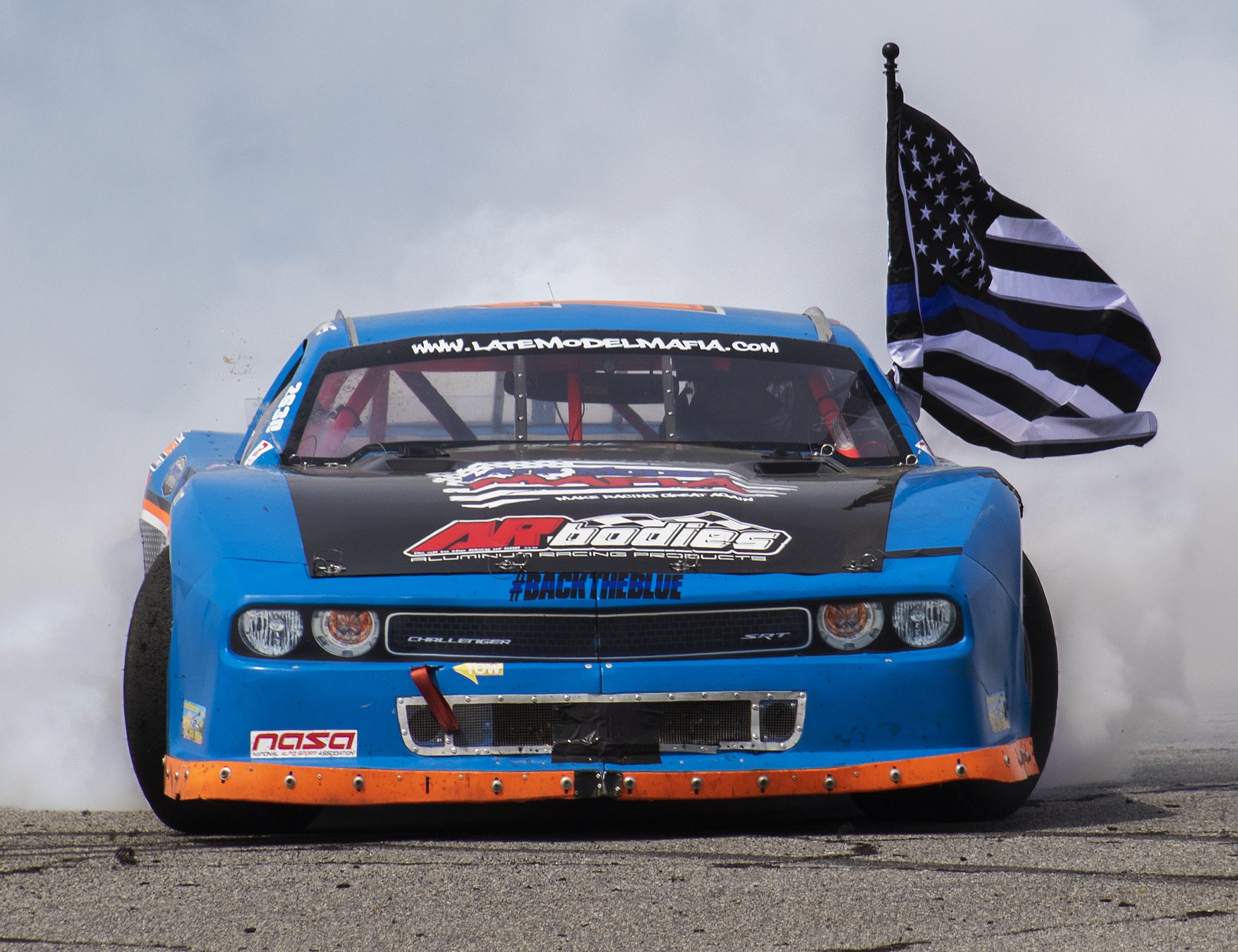 Challenger doing a burnout with a police flag