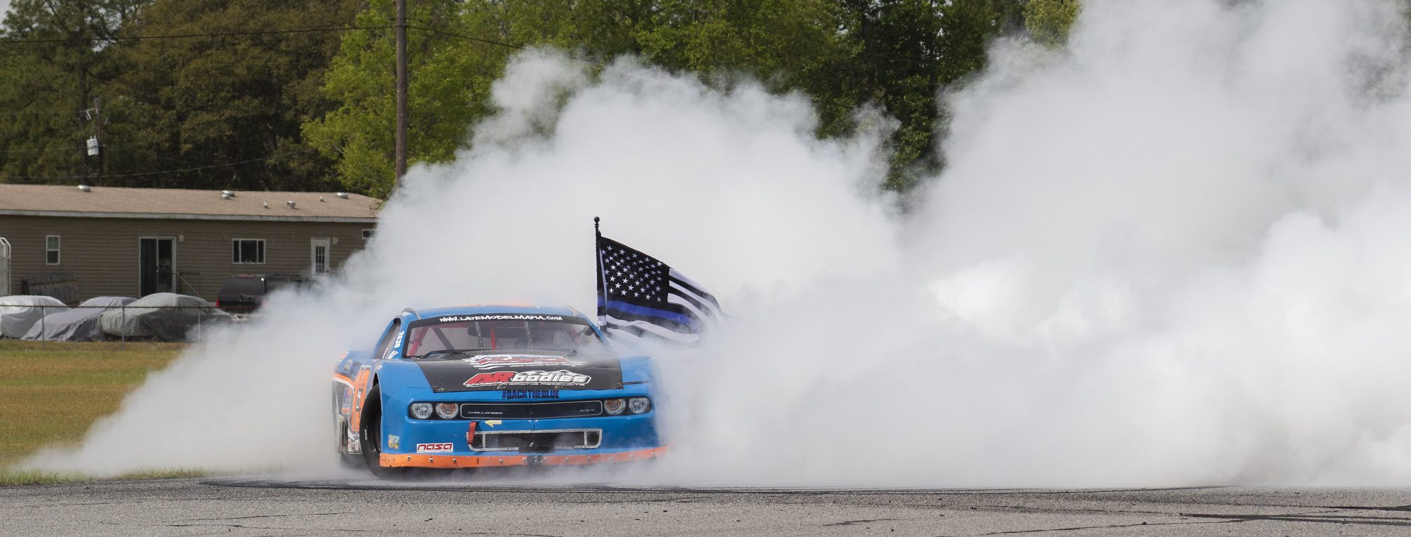 Challenger doing a burnout with a police flag