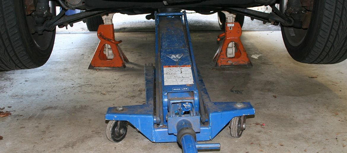 A car jack and jack stands holding up a vehicle