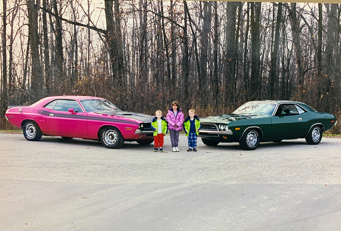 Old picture of three kids with two classic vehicles