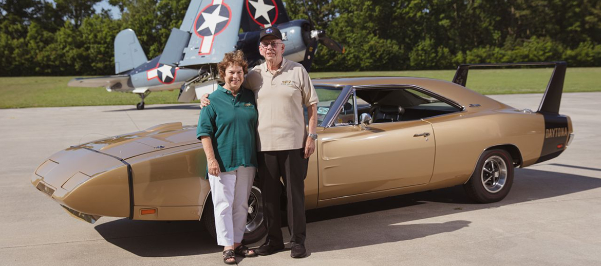 Man and woman standing with a Dodge Charger Daytona