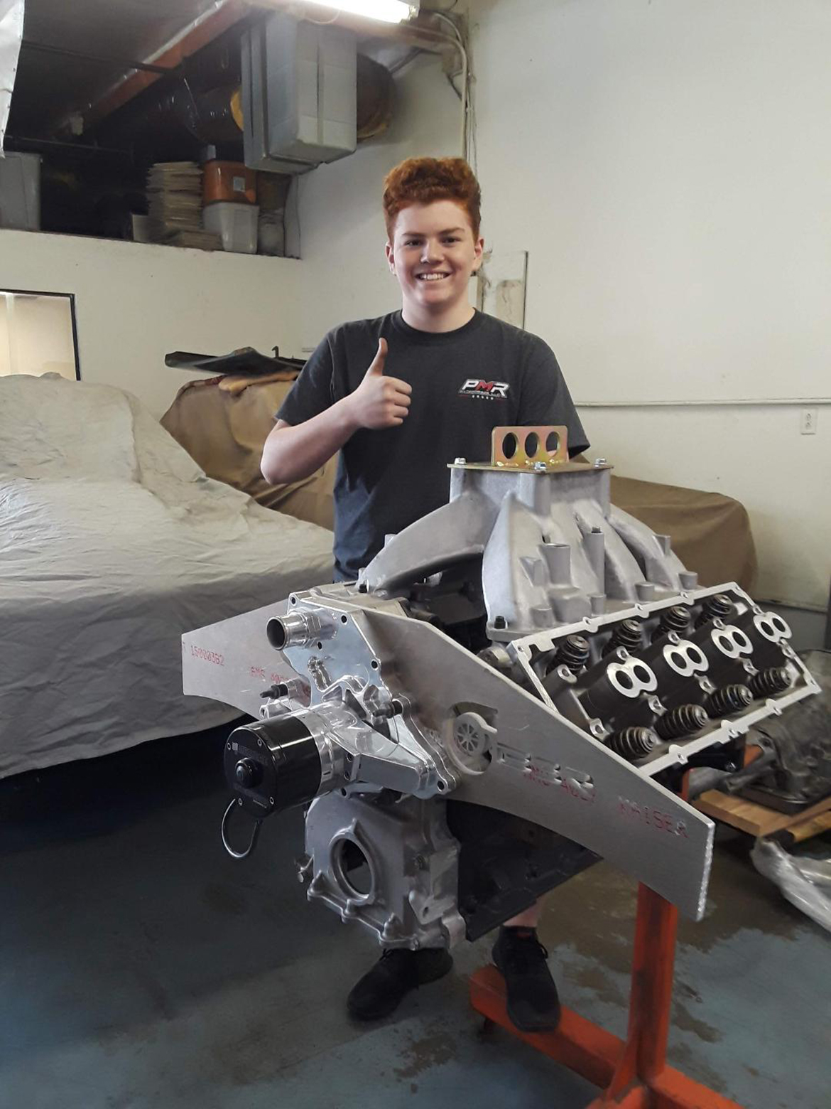 Teenage boy with a vehicle engine