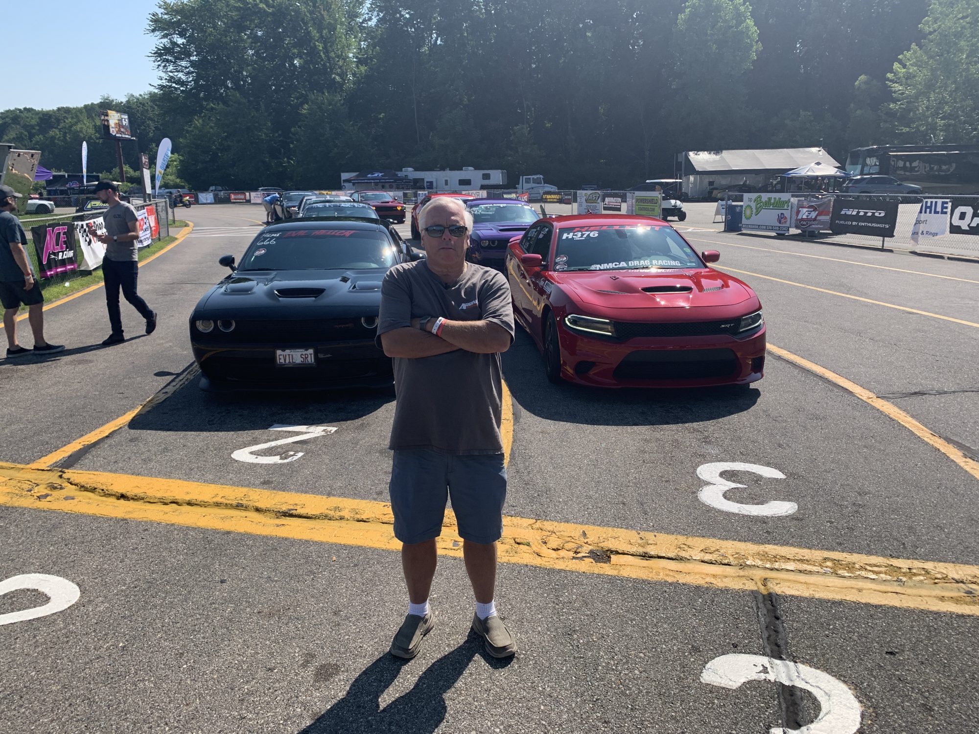 Man posing in front of line of Dodge vehicles
