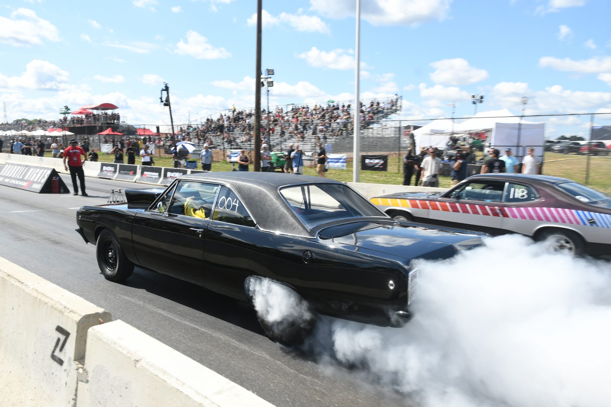 Two cars drag racing at Roadkill Nights Powered by Dodge