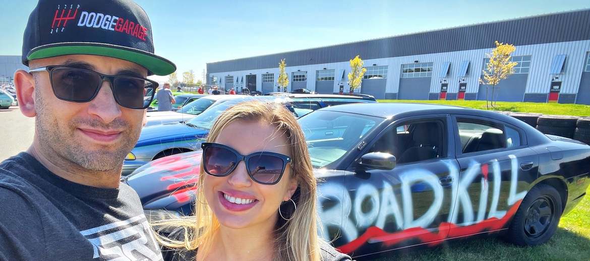 Couple posing in front of Roadkill car