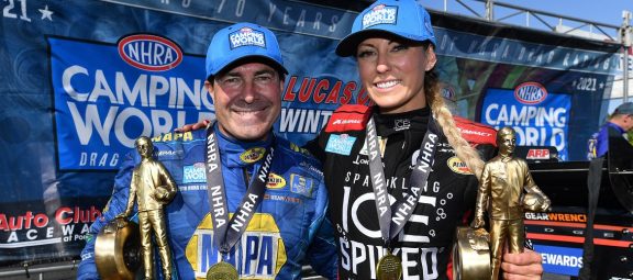 Ron Capps and Leah Pruett posing with their Wally trophies after a win
