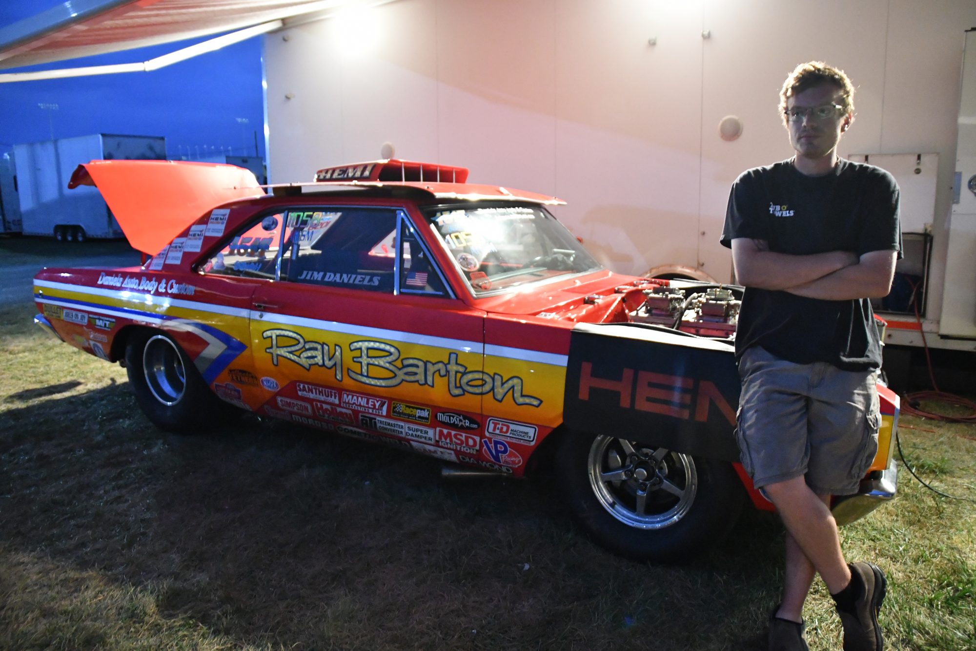 Man standing in front of his race car