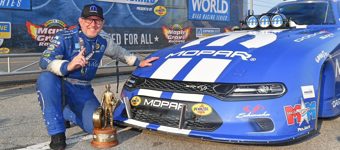 Tommy Johnson Jr posing next to car with Wally