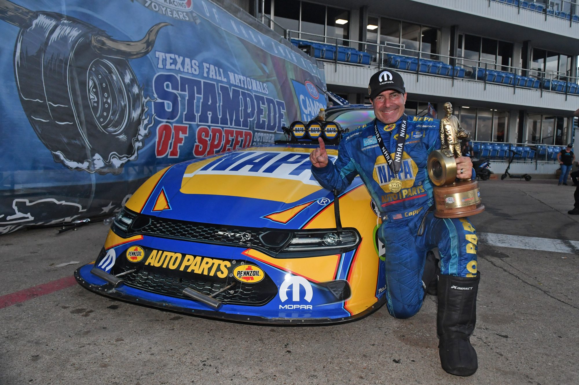 Ron Capps holding a Wally trophy after a win