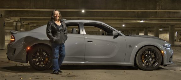 Woman standing next to her Dodge Charger