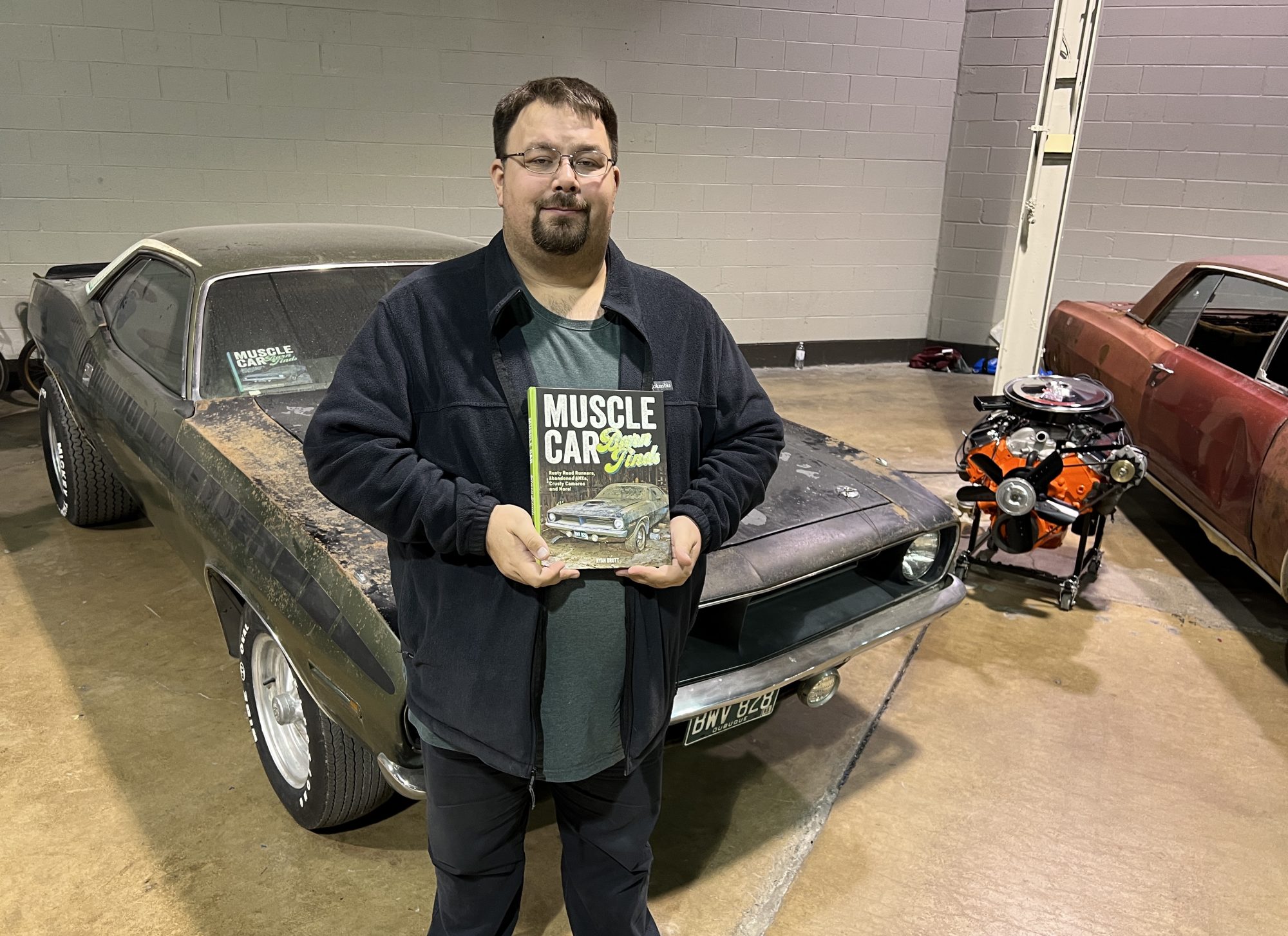 Man standing next to vintage Plymouth vehicle