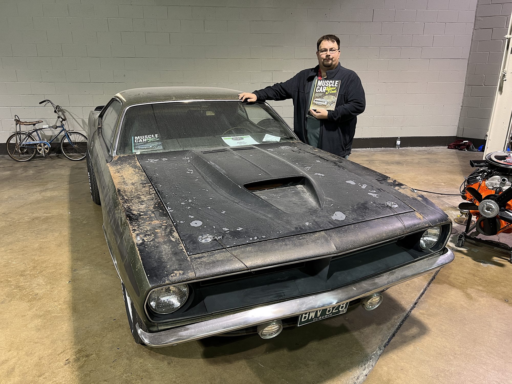 Man standing next to vintage Plymouth vehicle