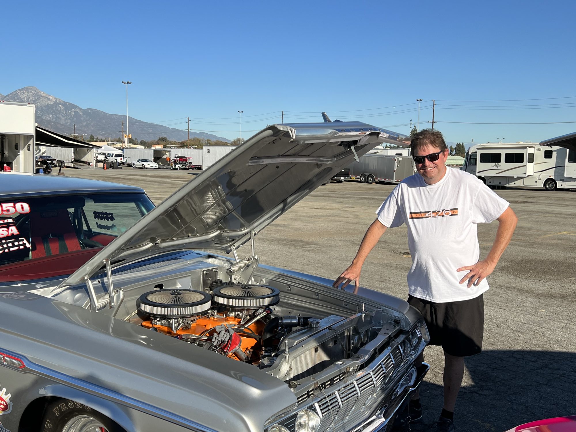 Man standing next to his race car